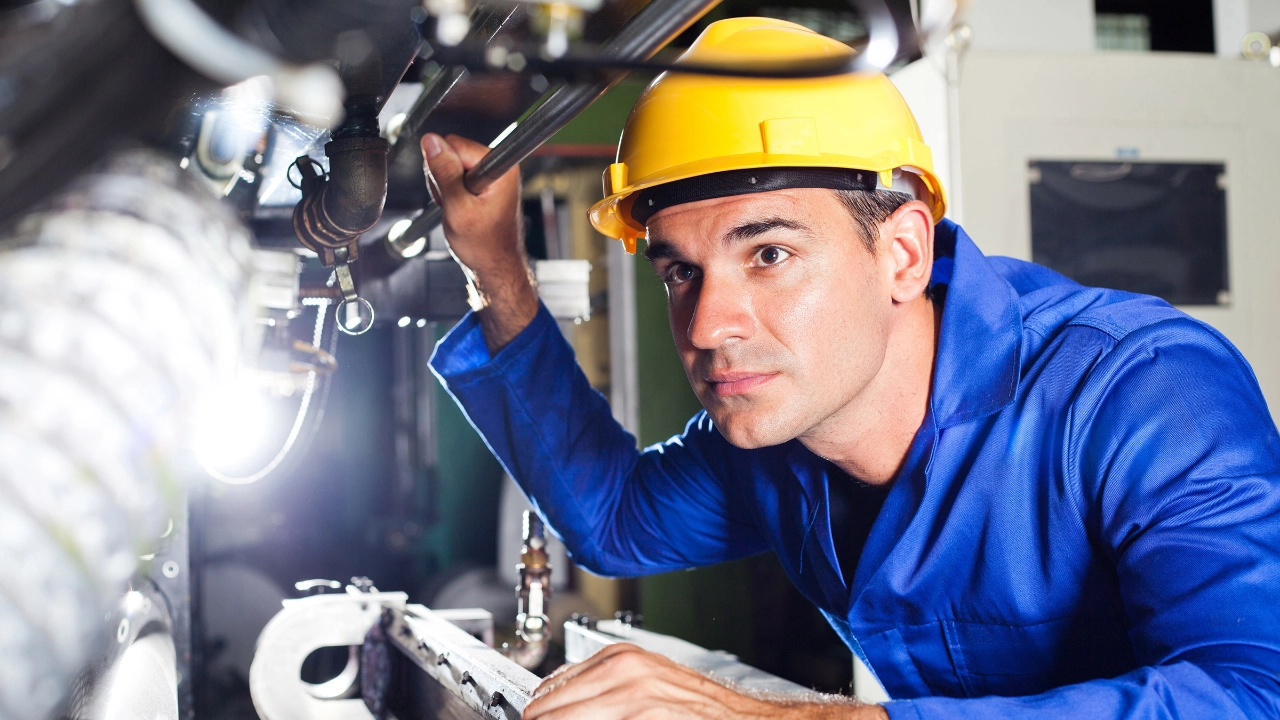 Arbeiter an einer Maschine in einer Produktionshalle