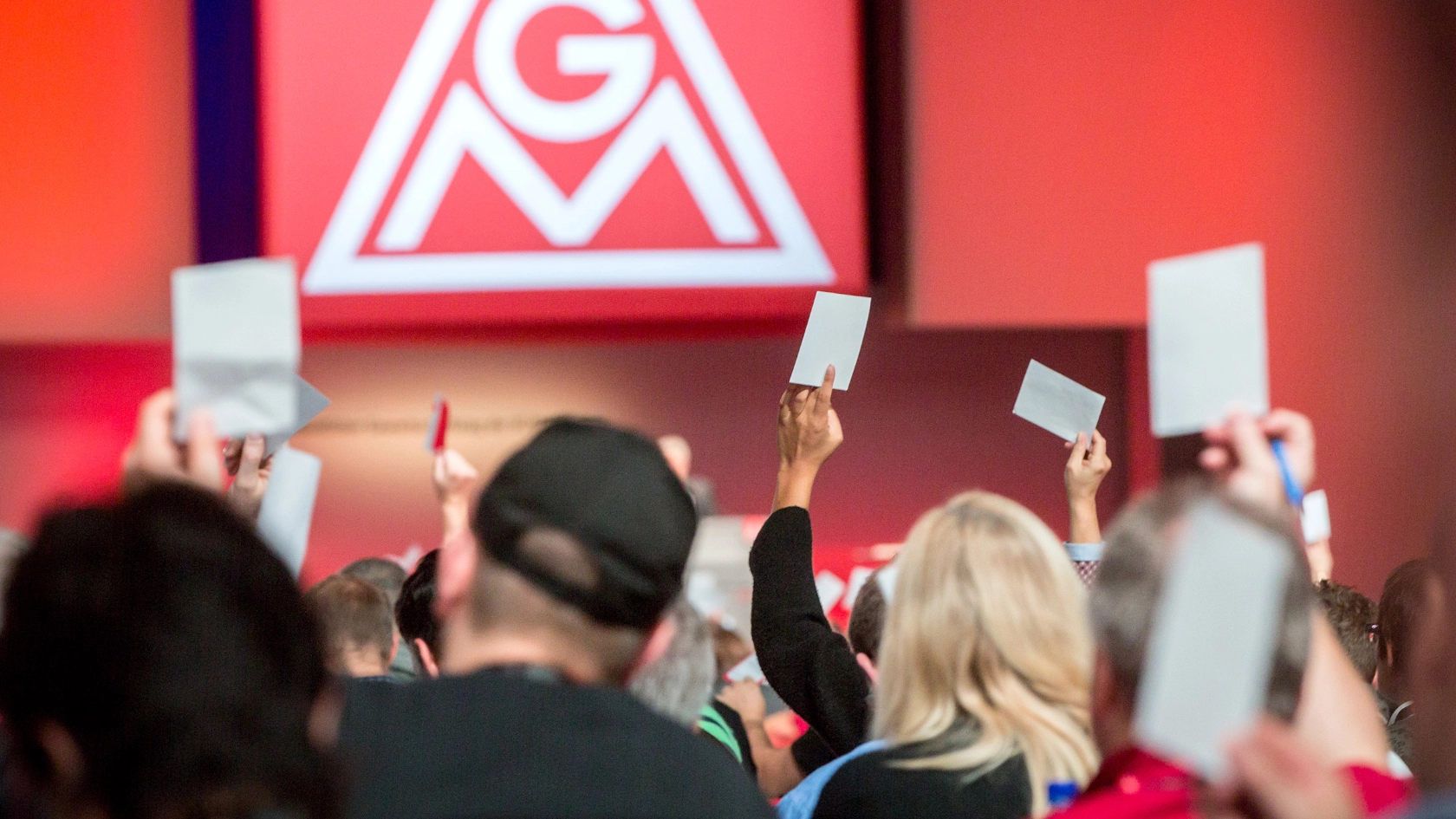 Menschen von hinten, die Abstimmungskarten nach oben halten.