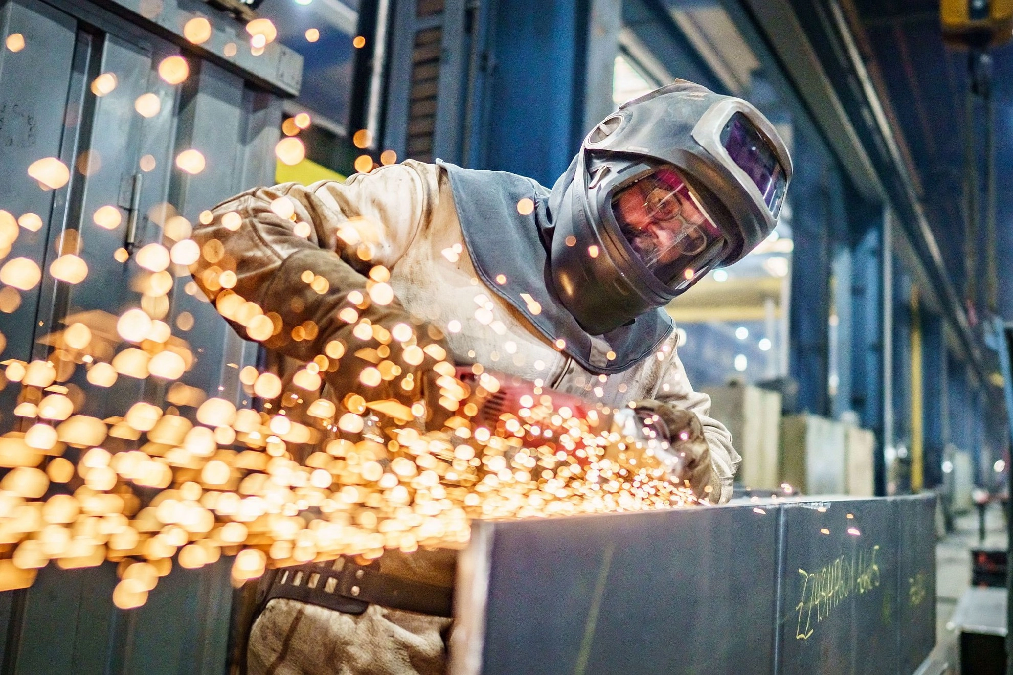 Metallhandwerker mit Trennschleifer, Funkenflug
